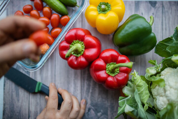Fresh and colorful bell peppers and other vegetables on wooden table