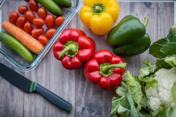 Fresh and colorful bell peppers and other vegetables on wooden table