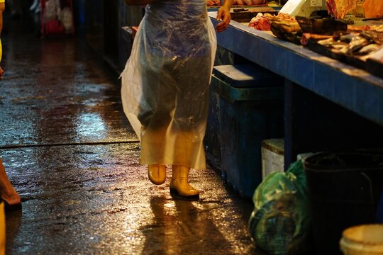 Low Section Of Person Walking On Street Market During Rainy Season