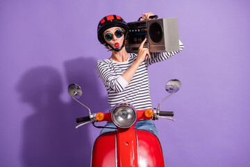 Portrait photo of girl in helmet motorbike pressing on button listening music boombox whistling...