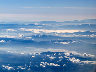 Obraz premium view from the airplane window of the mountains and clouds.