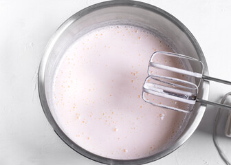 Step by step recipe of sponge cake. Step 4. Eggs and sugar mixed up to the fluffy foam in the metallic bowl to make the dough. Top view