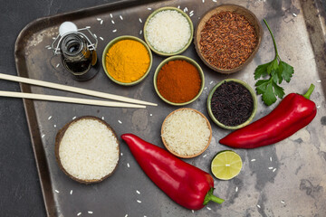 Different types of rice and spices. Soy sauce in glass jar. Raw Red Pepper. Bamboo sticks