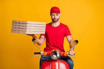 Photo of bearded guy ride motorbike hold carton pizza boxes wear red t-shirt cap isolated yellow...