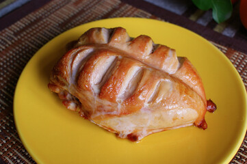 baked chicken breast. chicken breast with grilled crust on a yellow plate