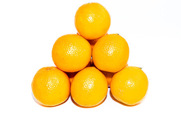 Pyramid of yellow orange ripe tangerines on a white backdrop