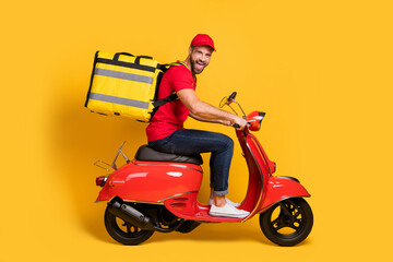 Profile photo of excited man drive bike open mouth wear bag red t-shirt hat jeans isolated yellow color background