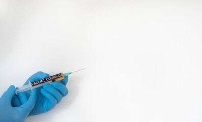 Coronavirus. A doctor's hands in protective blue gloves hold the syringe containing the covid-19 coronavirus vaccine. White background for copy space