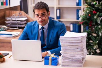 Young male employee working in the office at Chrismas