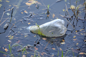   Plastic bottle floating in the water of a lake.