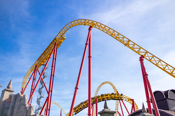 summer blurred photo of Rollercoaster against blue sky