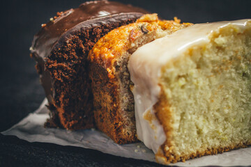 Fototapeta premium Slices of chocolate bread, banana bread, and lemon bread on rustic paper.