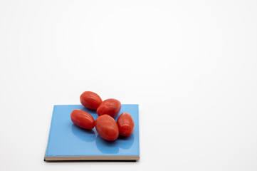 tomatoes on colored coasters and white background