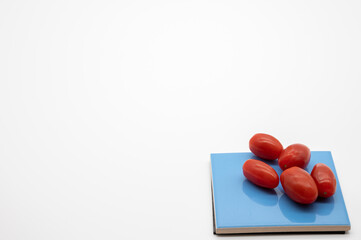tomatoes on colored coasters and white background