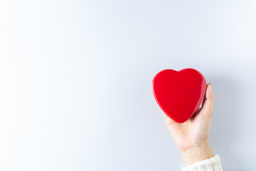 Obraz premium hands holding red heart. - health care, love, organ donation, mindfulness, wellbeing, concept. - world heart day, world health day, National Organ Donor Day.