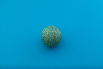 Shiny Christmas ball on a blue background. Selective focus, copy space