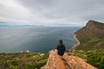 Woman having scenic view to False Bay from Cape of Good Hope nature reserve, South Africa.