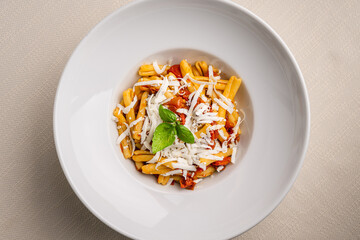 Casarecce pasta withe cherry tomatoes, parmesan cheese and fresh basil on white background. Close up
