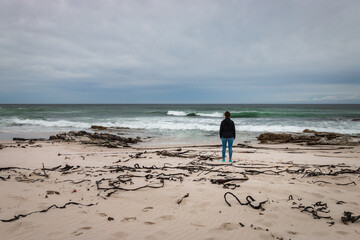 Woman standing at Platboom beach, Cape of Good Hope, South Africa.