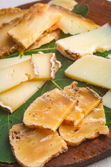various cheeses on the wooden board isolated on white background

