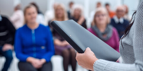 teacher with a folder in his hand teaches elderly people business in the conference room