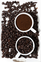 cups with ground coffee and coffee beans, top view
