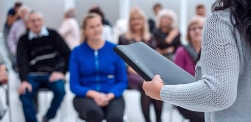 teacher with a folder in his hand teaches elderly people busines