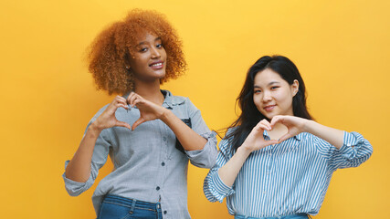 Multiracian homosexual relationship concept. African american black and asian woman making hearts with hands. High quality photo