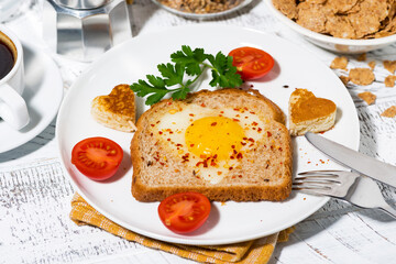 fried egg in a heart shape in toast for breakfast, closeup