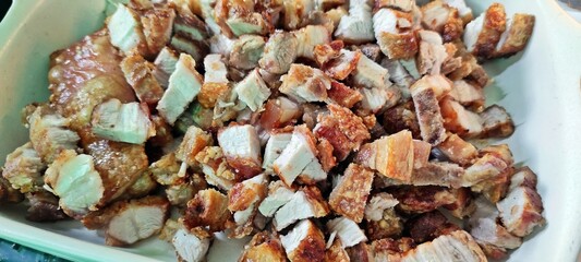 Crispy pork belly in white tray.
