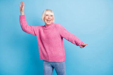 Photo portrait of elderly woman dancing isolated on pastel blue colored background