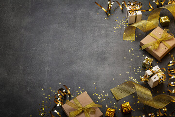 Bright golden card with holiday gifts, lovely ribbon, confetti stars and place for an inscription on a dark background