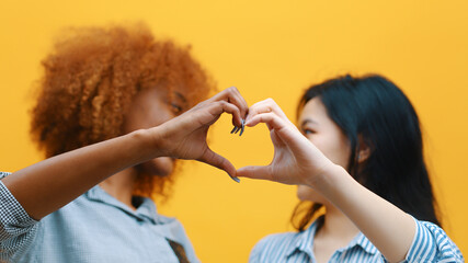 Multiracian homosexual relationship concept. African american black and asian woman making hearts with hands. High quality photo