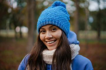 Beautiful happy woman smiling while strolling in autumn forest