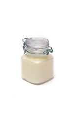 white candle in a glass jar on a white background
