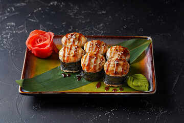 Baked sushi roll Canada on dark background.