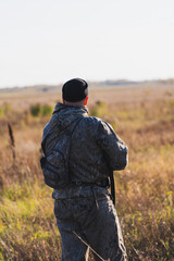 Male hunter in camouflage clothes ready to hunt with hunting rifle