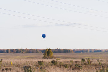 Blue hot air balloon flying in the sky at sunset