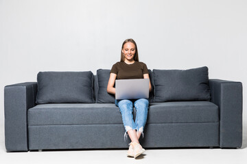Fototapeta na wymiar A pretty woman wearing casual clothes with laptop sit on sofa isolated on white background