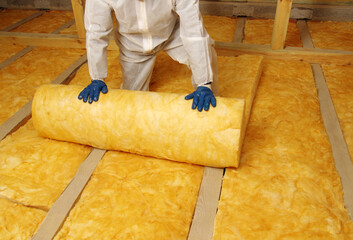 Worker insulate the attic with mineral wool