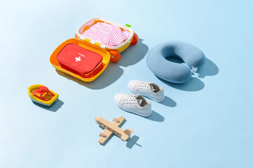 Composition of child accessories and first aid kit on color background. Travel concept