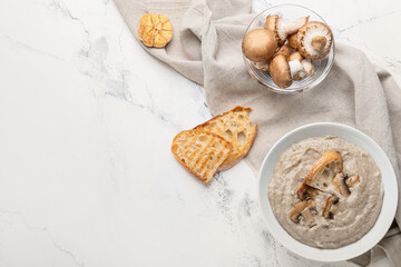 Bowl of tasty mushroom cream soup on light background