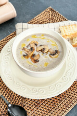 Bowl of tasty mushroom cream soup on table