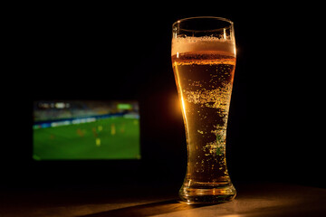 A pint of foaming lager and football on TV.