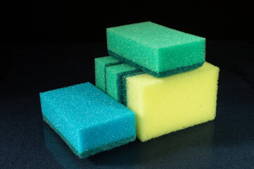 Sponge for dishwashing on glass table on black background