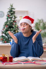 Young male student preparing for exams during new year celebrati