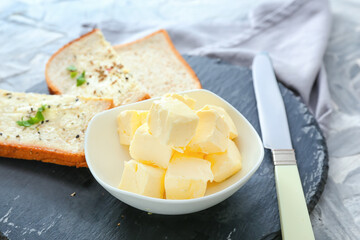 Bread and bowl with butter, and knife on table