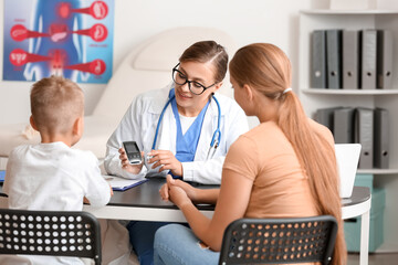 Diabetic boy with mother visiting doctor in clinic