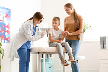 Obraz premium Doctor giving diabetic boy insulin injection in clinic