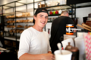 Smiling young man at work at cafe